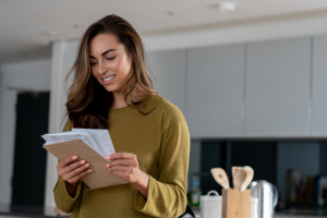 Woman looking at letters and envelope